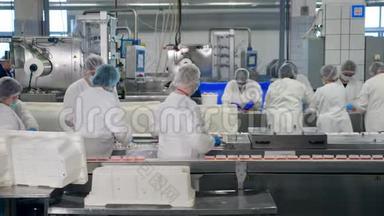 女工人正在食品厂的传送带上更换<strong>包装</strong>好的<strong>零食</strong>。